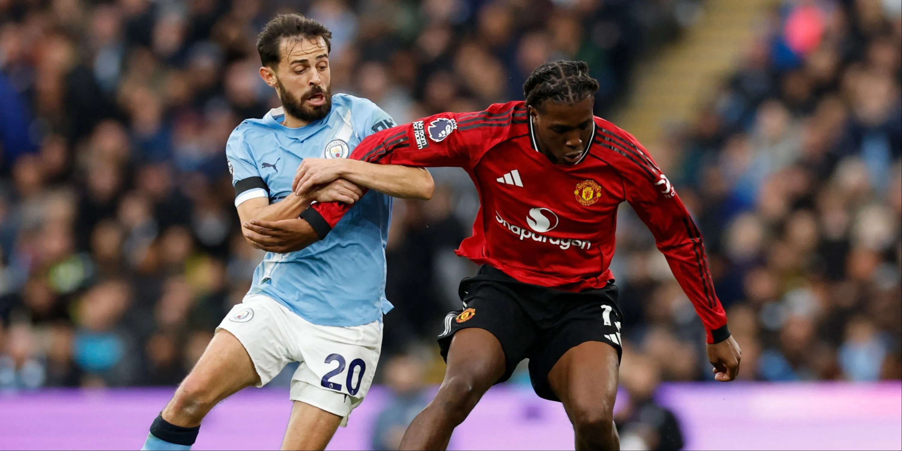 Patrick Dorgu đối đầu với Bernardo Silva trong một pha bóng tranh chấp